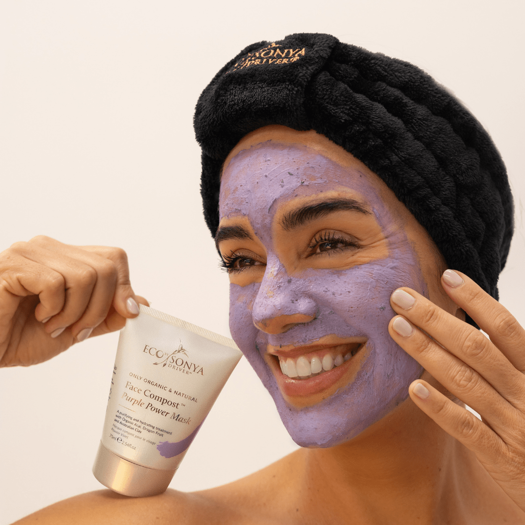 Woman applying purple power face mask with black velvet elastic headband